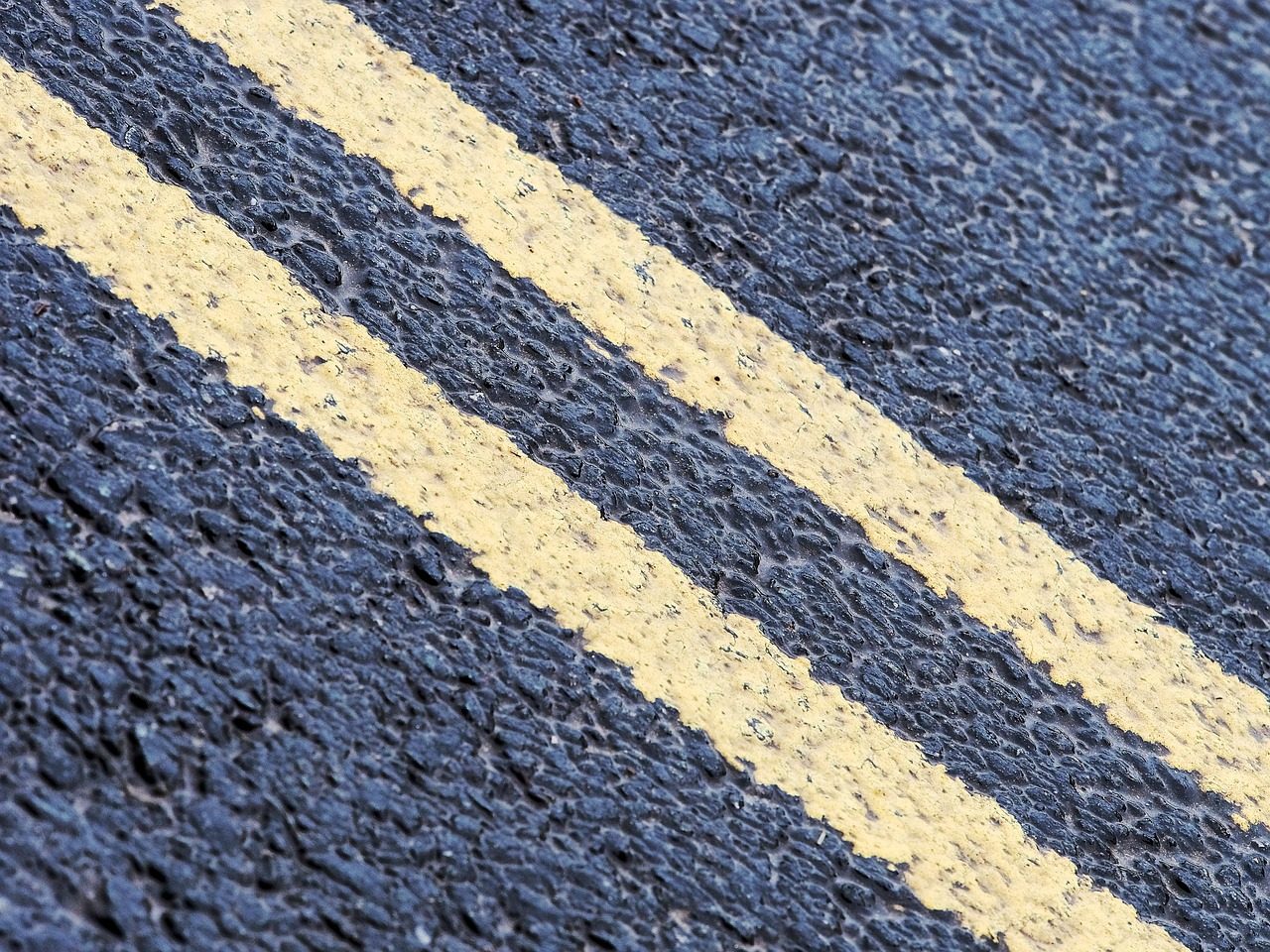 Freshly painted yellow line striping on asphalt